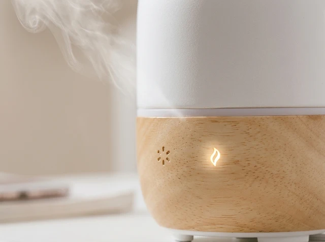 Man working in library beside fireplace diffuser